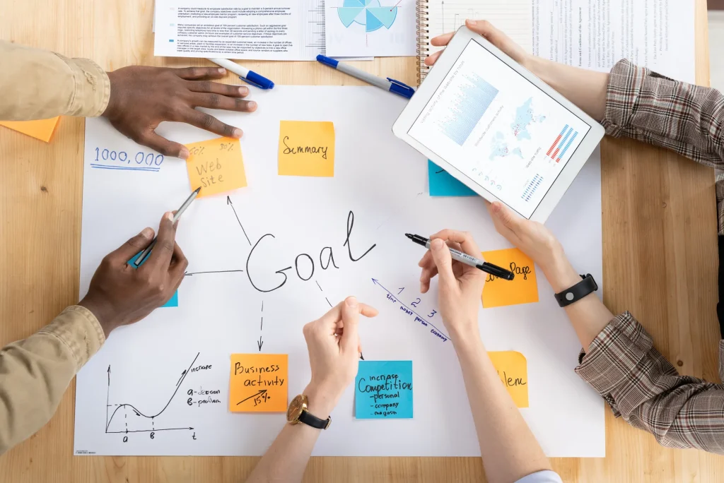 Plano cenital de un equipo de trabajo realizando una planeación estratégica con datos e ideas.