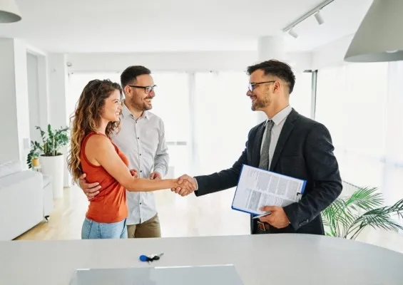 Foto de una pareja dando la mano a hombre que ayuda en la consultoría empresarial en mejora contínua